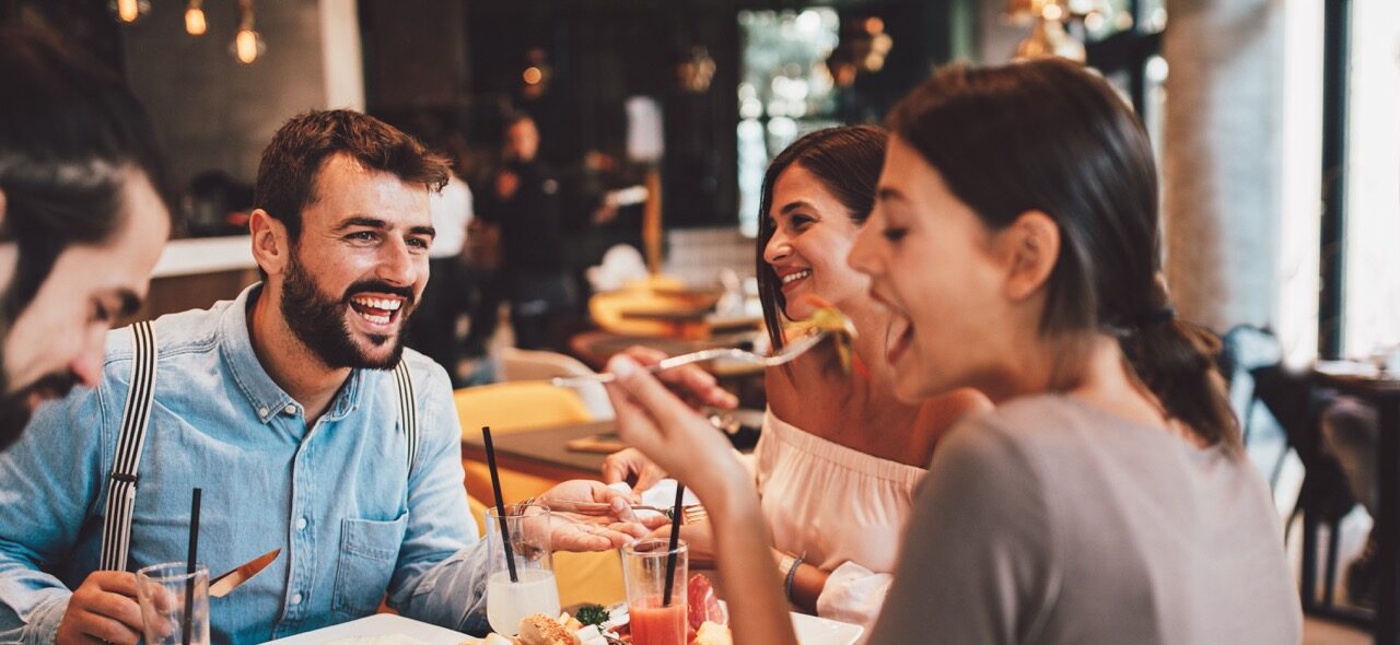 People enjoying brunch at a table with drinks and plates in a bright restaurant dining area